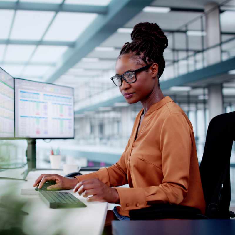 Woman working on multiple monitors